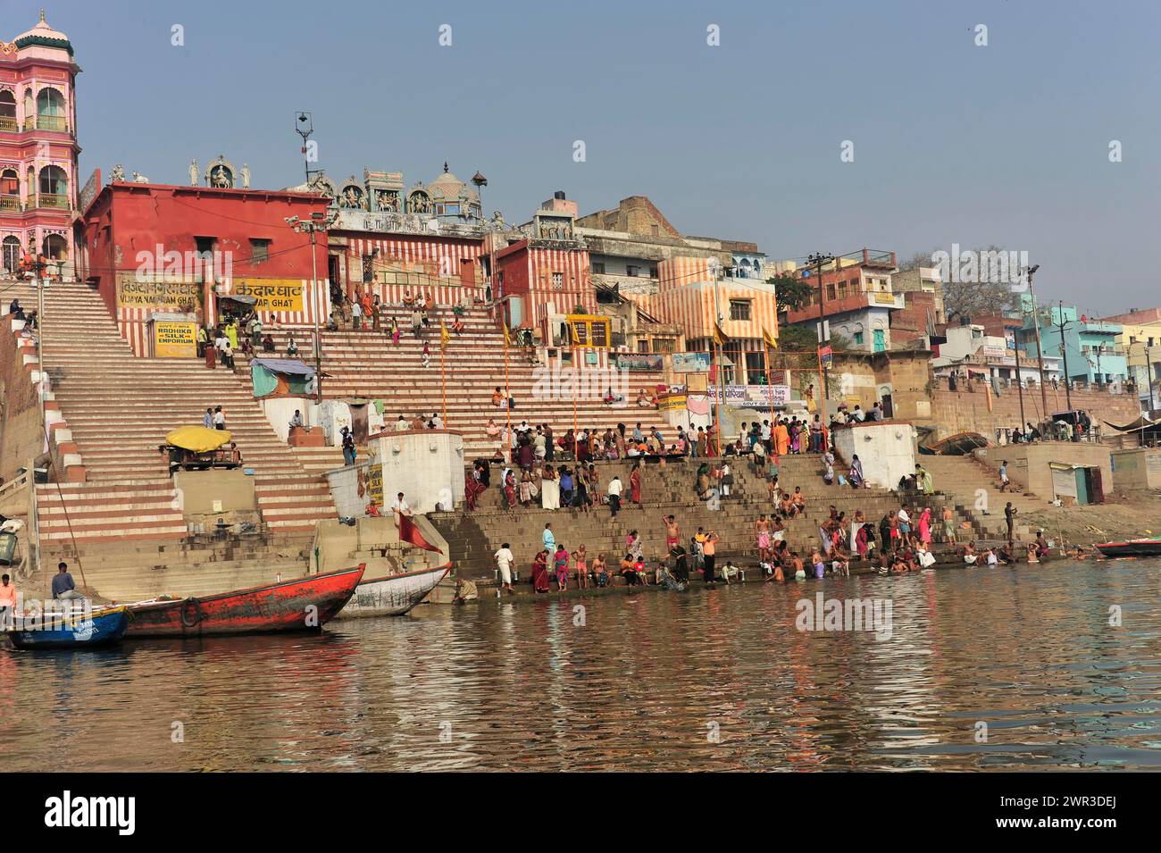 Lebhafte Uferpromenade mit Menschenmassen und traditionellen Gebäuden, Varanasi, Uttar Pradesh, Indien Stockfoto