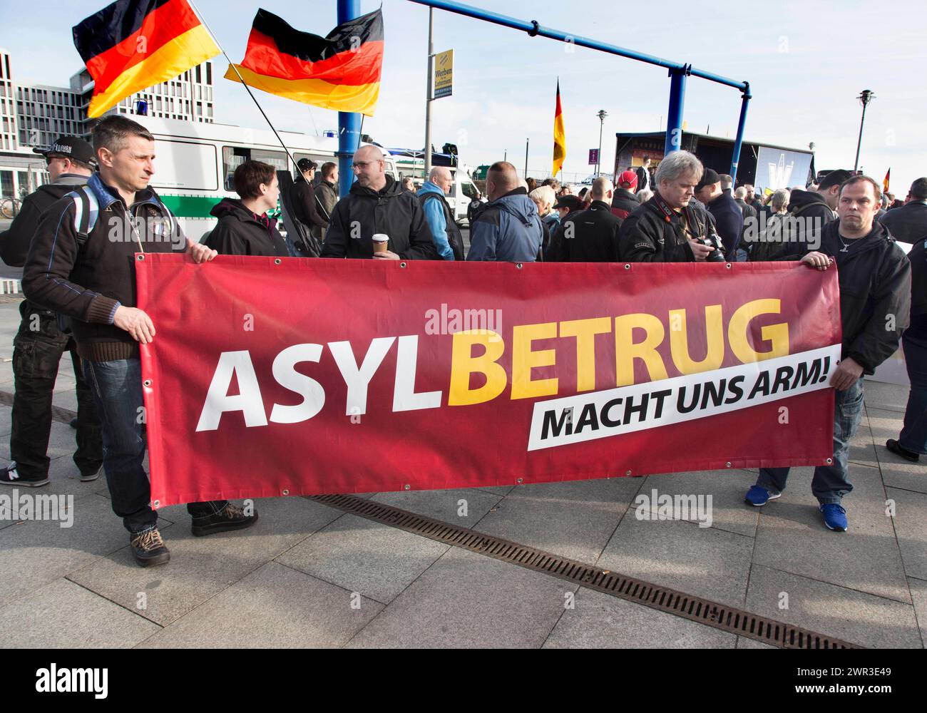 Die Teilnehmer der Demonstration Merkel muss weg halten ein Schild mit der Aufschrift Asylbetrug macht uns Arm. Demonstration von Rechtspopulisten und Rechtspopulisten Stockfoto