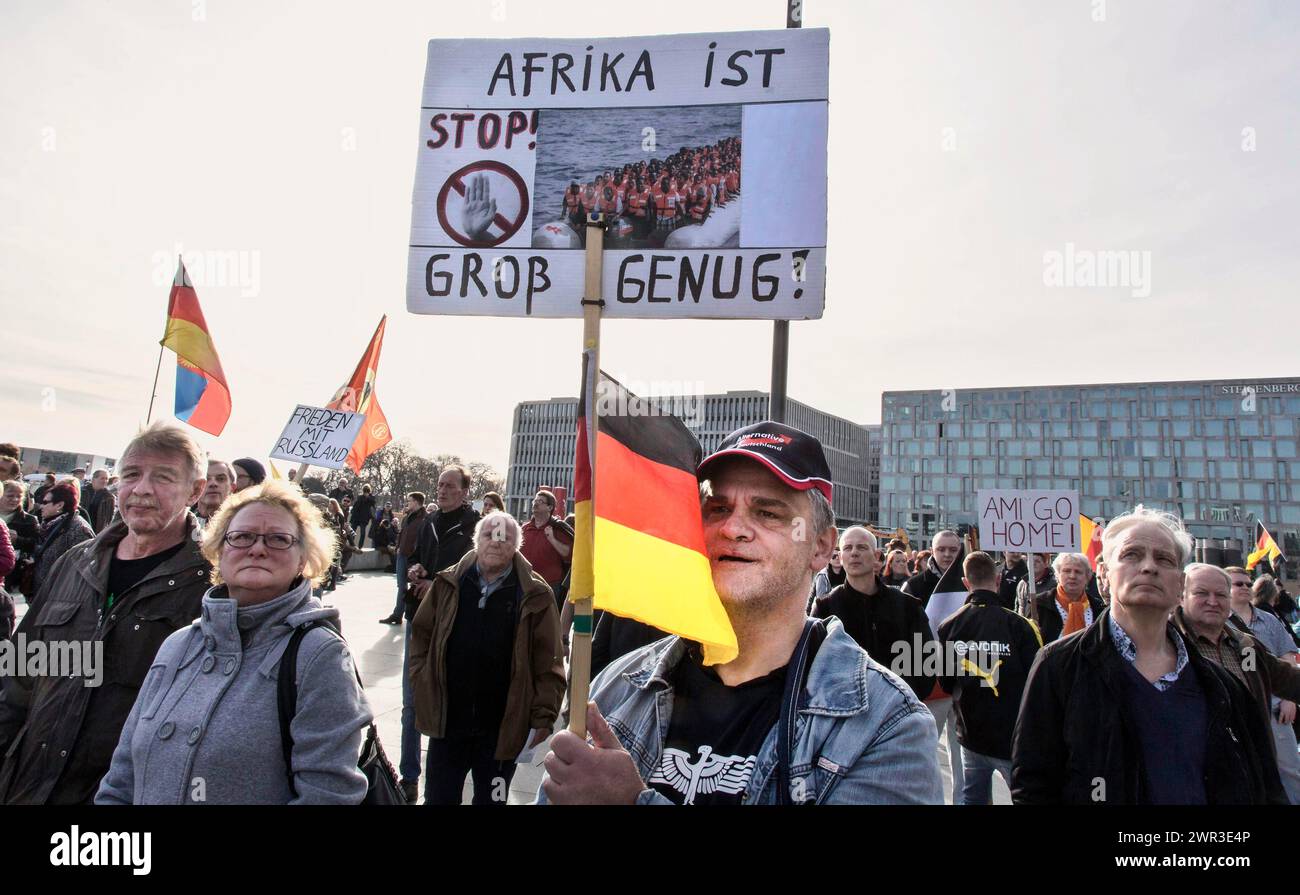 Ein Teilnehmer der Merkel muss weg-Demonstration trägt eine AFD-Mütze und hält ein Schild mit der Aufschrift „Afrika ist gross genug“. Stockfoto
