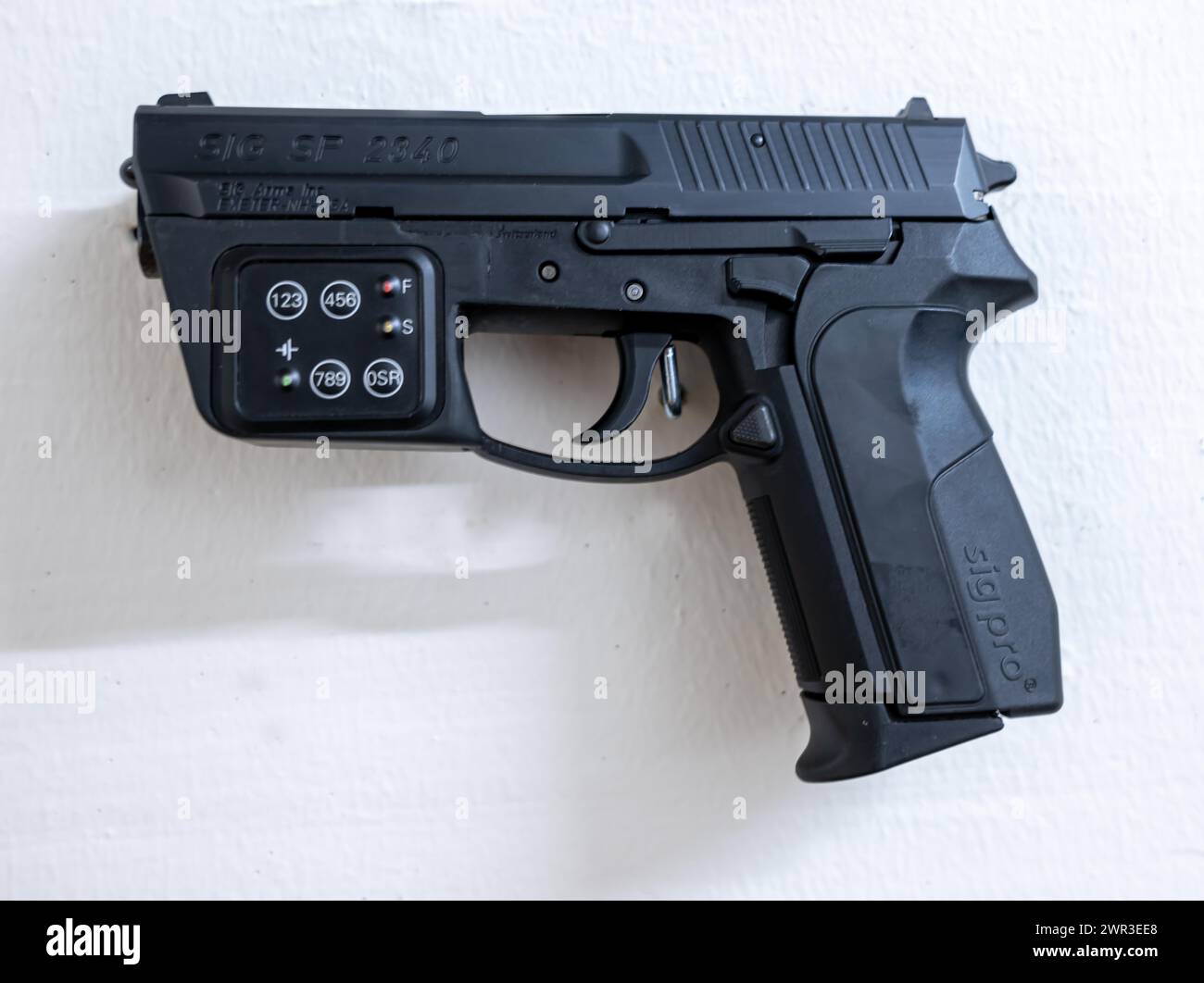 Neue moderne Handpistole SIG SP2340 Prototyp mit elektronischem Kombinationsschloss, das in der Schweiz an einer Wand hängt Stockfoto