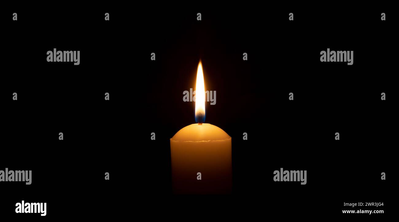 Einzelne brennende Kerzenflamme oder Licht leuchtet auf einer großen weißen Kerze auf schwarzem oder dunklem Hintergrund auf dem Tisch in der Kirche zu Weihnachten, Beerdigung Stockfoto