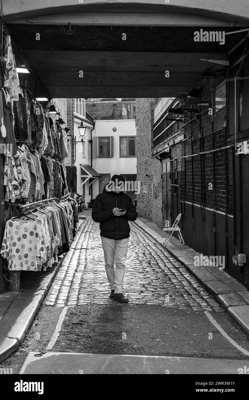 Der Anbieter wartet auf den Kunden auf der Portobello Road in Schwarz-weiß Stockfoto