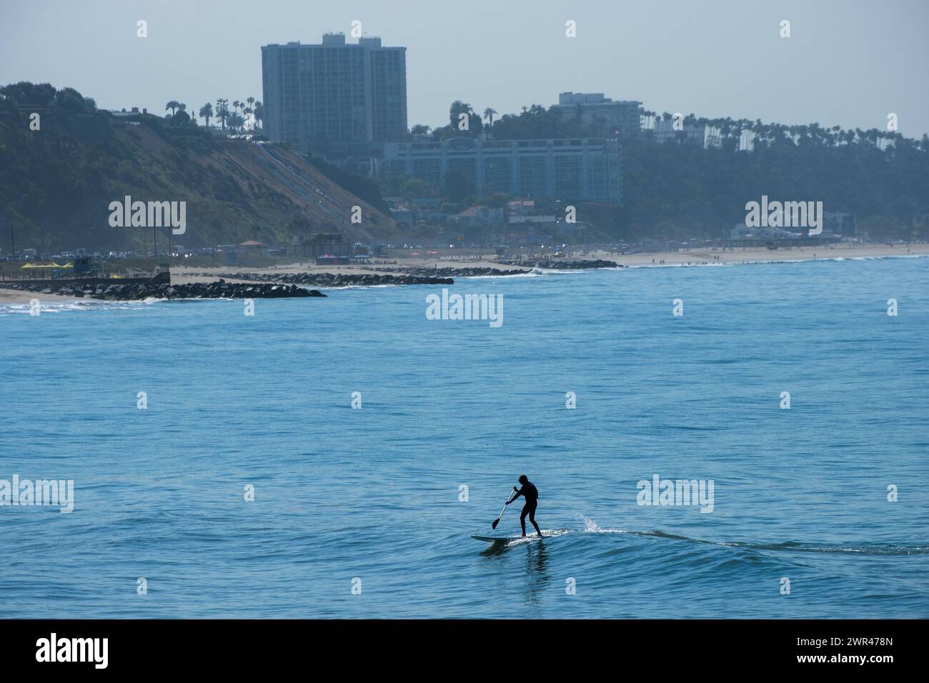 Stand-Up Paddle Board Surfer beim Surfen am Sunset Beach in Pacific Palisades, Kalifornien, USA. Stockfoto
