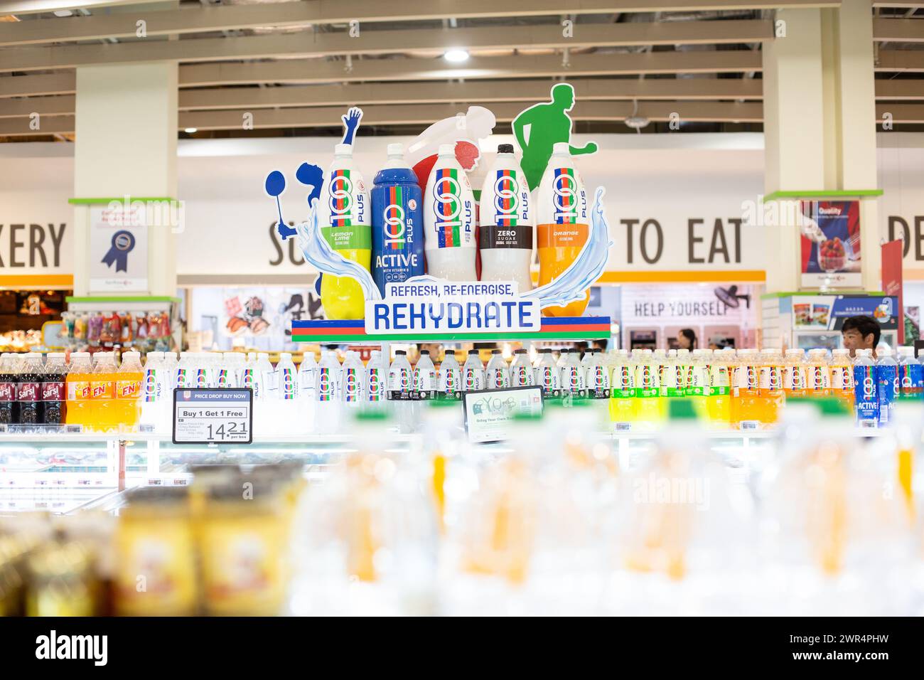 Riesige Flaschen mit 100plus isotonischen Sportgetränken und Board-Design werden an einer höheren Stelle gezeigt, um Menschen zum Kauf zu bewegen, um Durst zu stillen. Singapur. Stockfoto