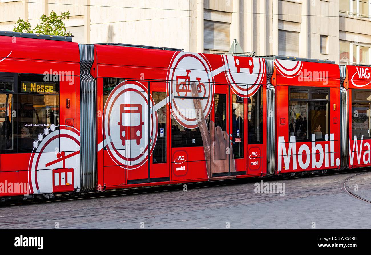 Eine Strassenbahn in Freiburg fährt am Platz der alten Synagoge vorbei. Auf der Seite sind verschiedene Mobilitätsformen zu finden. (Freiburg im Breis Stockfoto