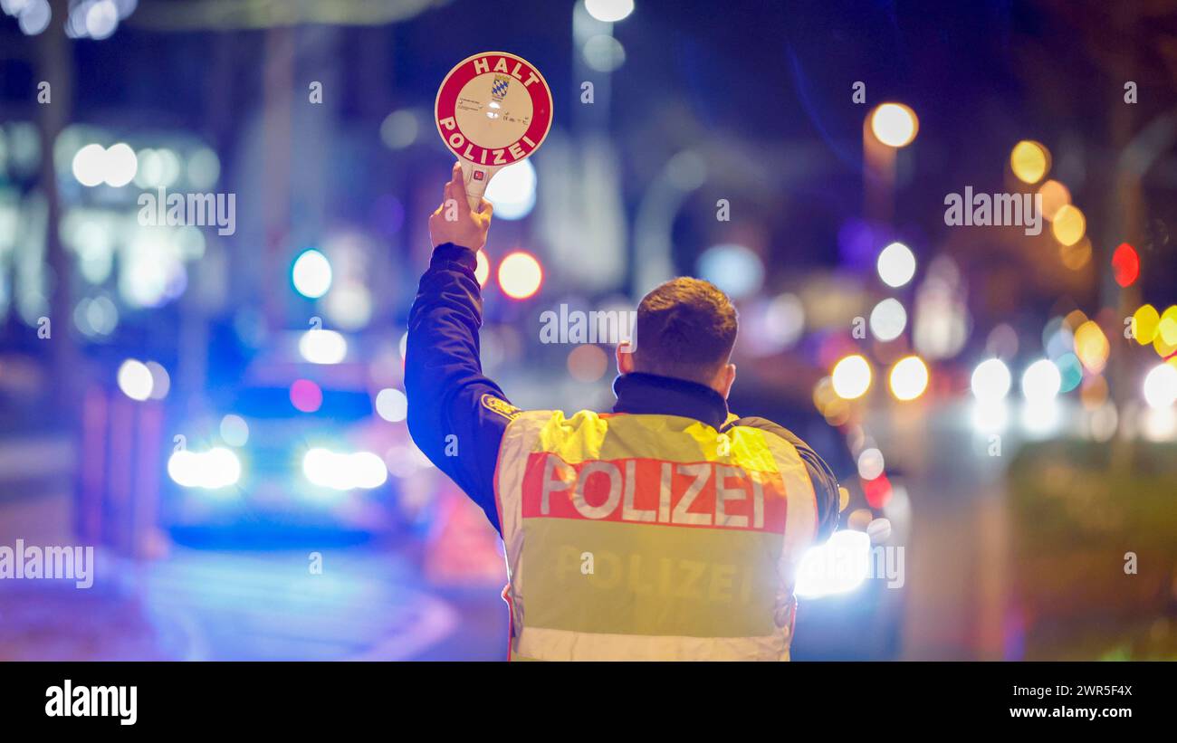 Aschaffenburg, Deutschland. März 2024. Ein Polizist hält einen Verkehrsteilnehmer mit dem Schild „Stop Police“ an. Quelle: Heiko Becker/HMB Media /dpa/Alamy Live News Stockfoto