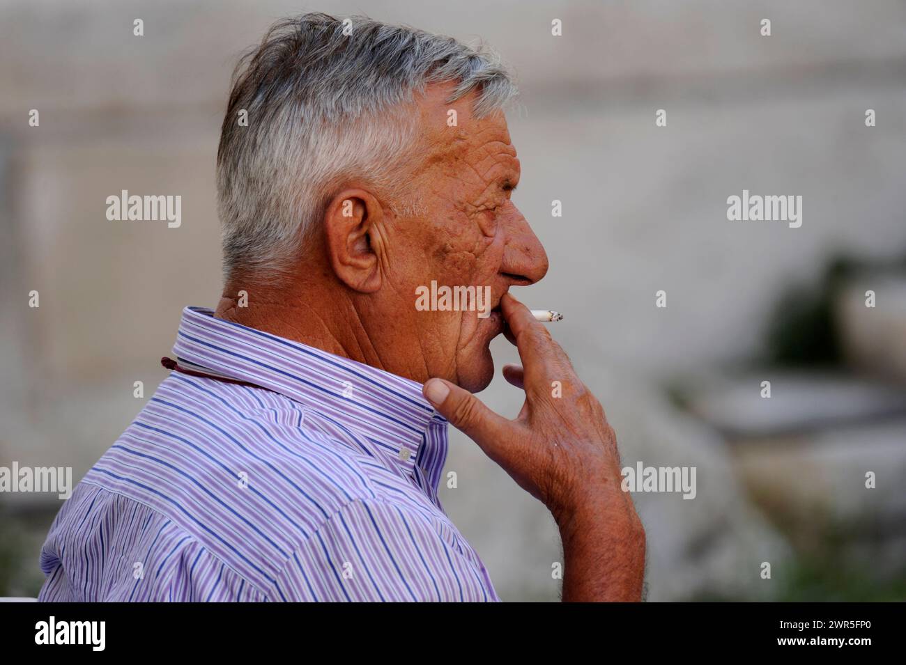 Kroatischer alter Mann, der eine Zigarette raucht, ungesunder Lebensstil Stockfoto