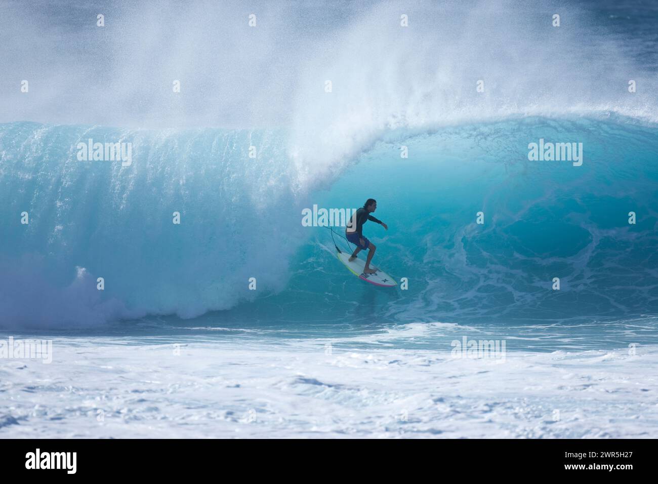 Ein junger Mann, der in Pipeline surft, North Shore, Hawaii. Stockfoto