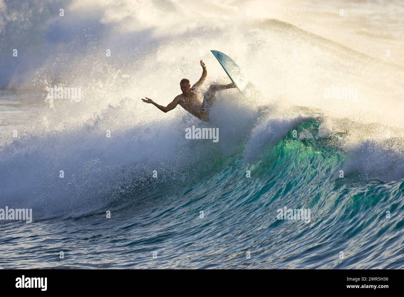 Ein junger Mann, der bei Rubber Duckies am Nordufer von Oahu surft Stockfoto