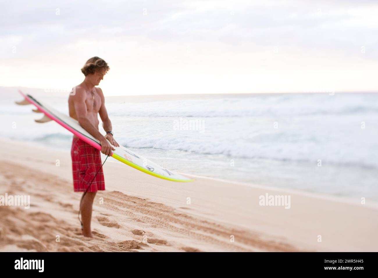 Ein Surfer am Strand von Pipeline, Hawaii Stockfoto