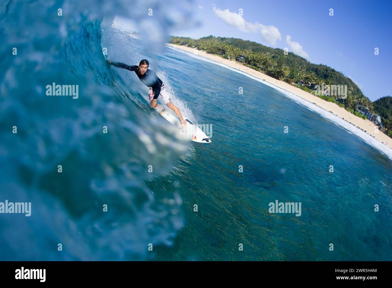 Ein Blick vom Wasser eines jungen Mannes, der an Off the Wall an der Nordküste Hawaiis surft. Stockfoto