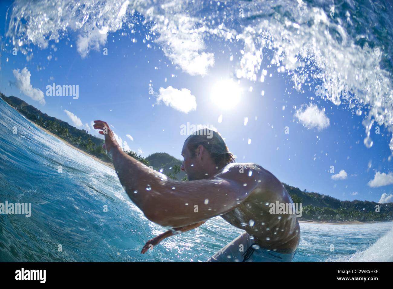 Ein sehr breiter Blick auf das Wasser eines jungen Mannes, der am Rocky Point am Nordufer von Oahu surft. Hawaii Stockfoto
