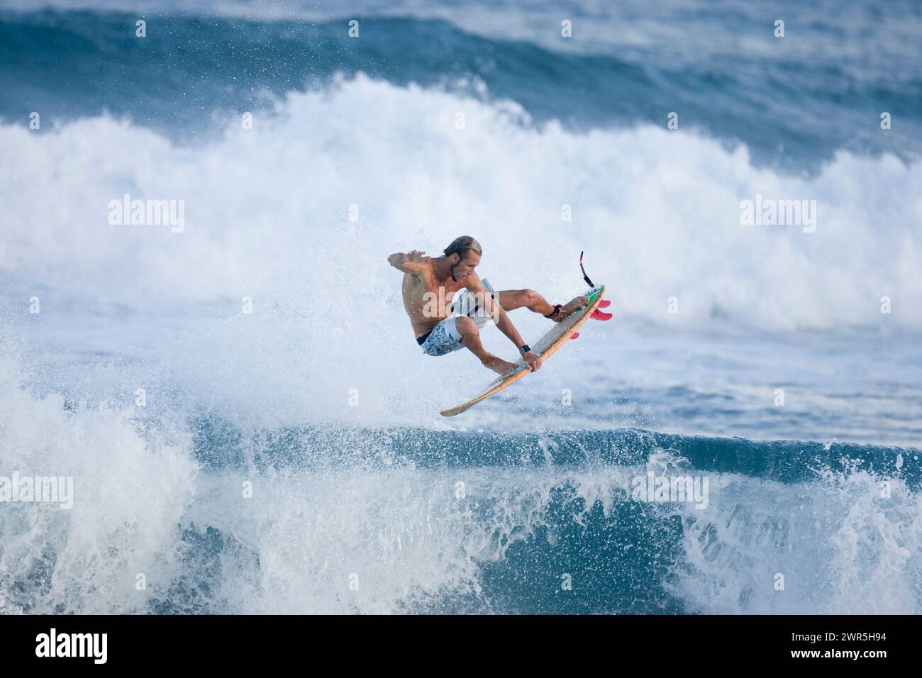 Ein junger Mann beim Surfen in Rocky Point, am Nordufer von Oahu, Hawaii Stockfoto