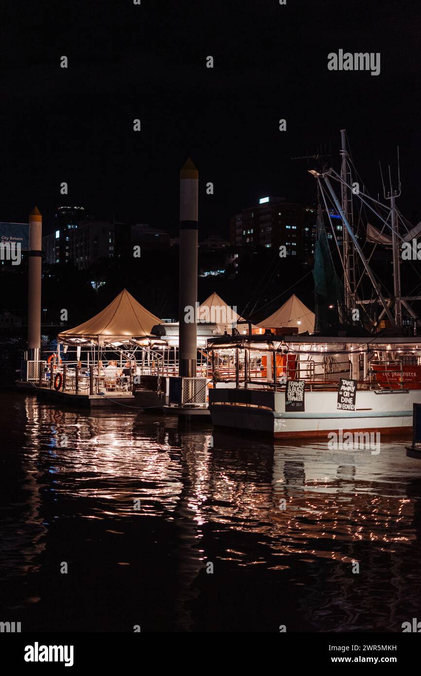 Boote, die nachts am Pier vorbeischwimmen Stockfoto