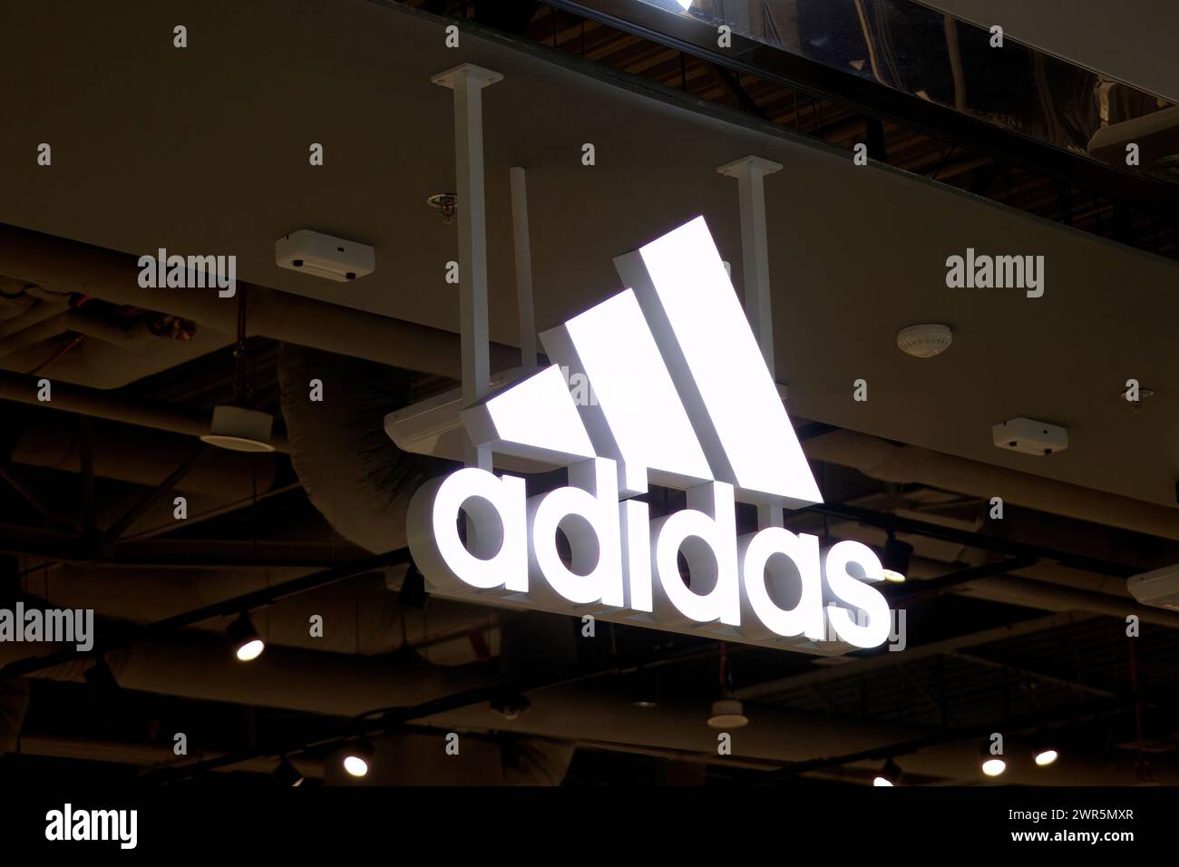 Adidas-Schild, Logo vor dem Adidas-Shop. Adidas ist ein weltweit tätiger Händler für Sportbekleidung und Laufschuhe. Stockfoto