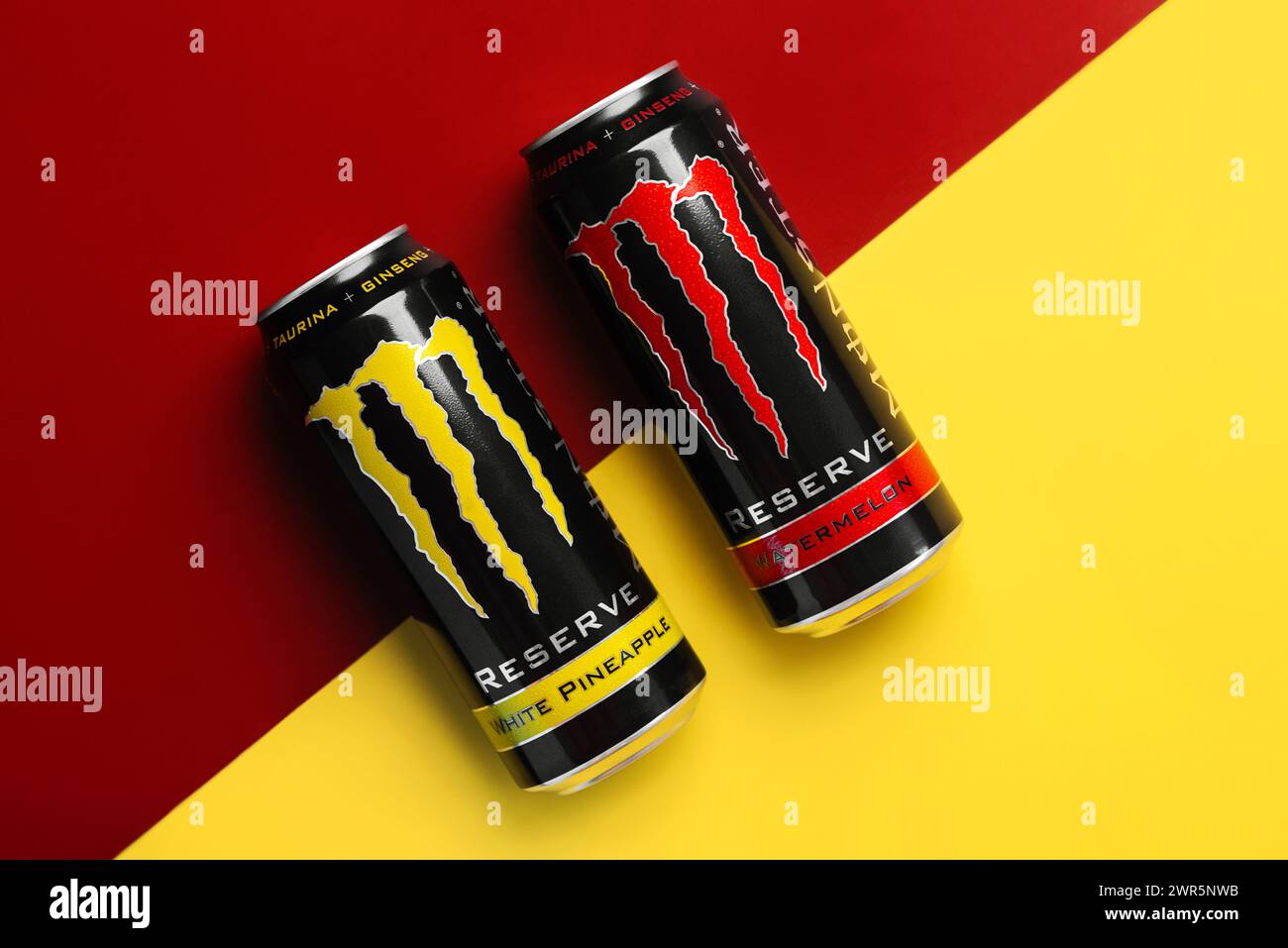 Dosen von Monster Energy trinken weiße Ananas und Wassermelone auf rotem und gelbem Hintergrund. Illustrativer Leitartikel Stockfoto