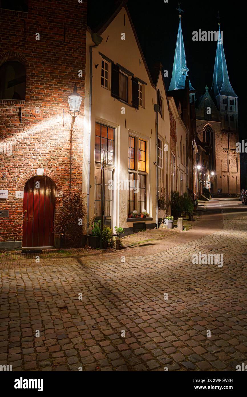 Malerische Stadt bei Nacht mit beleuchteten Straßen und monumentalen Gebäuden im niederländischen Dorf Deventer in den Niederlanden Stockfoto