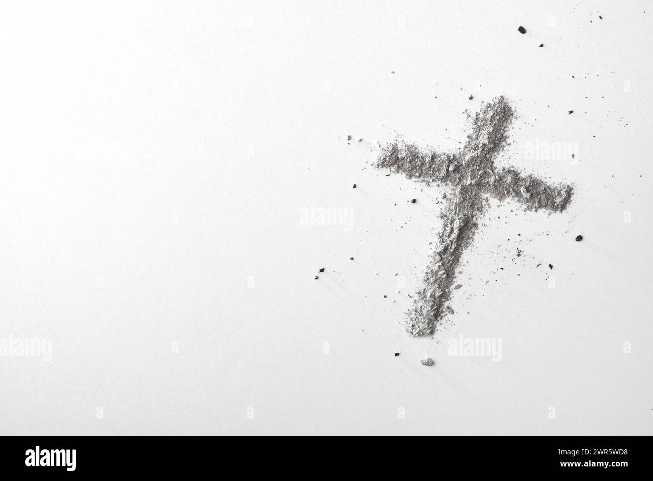 Christliches Kreuz mit Asche isoliert auf weißem Tisch. Draufsicht. Stockfoto