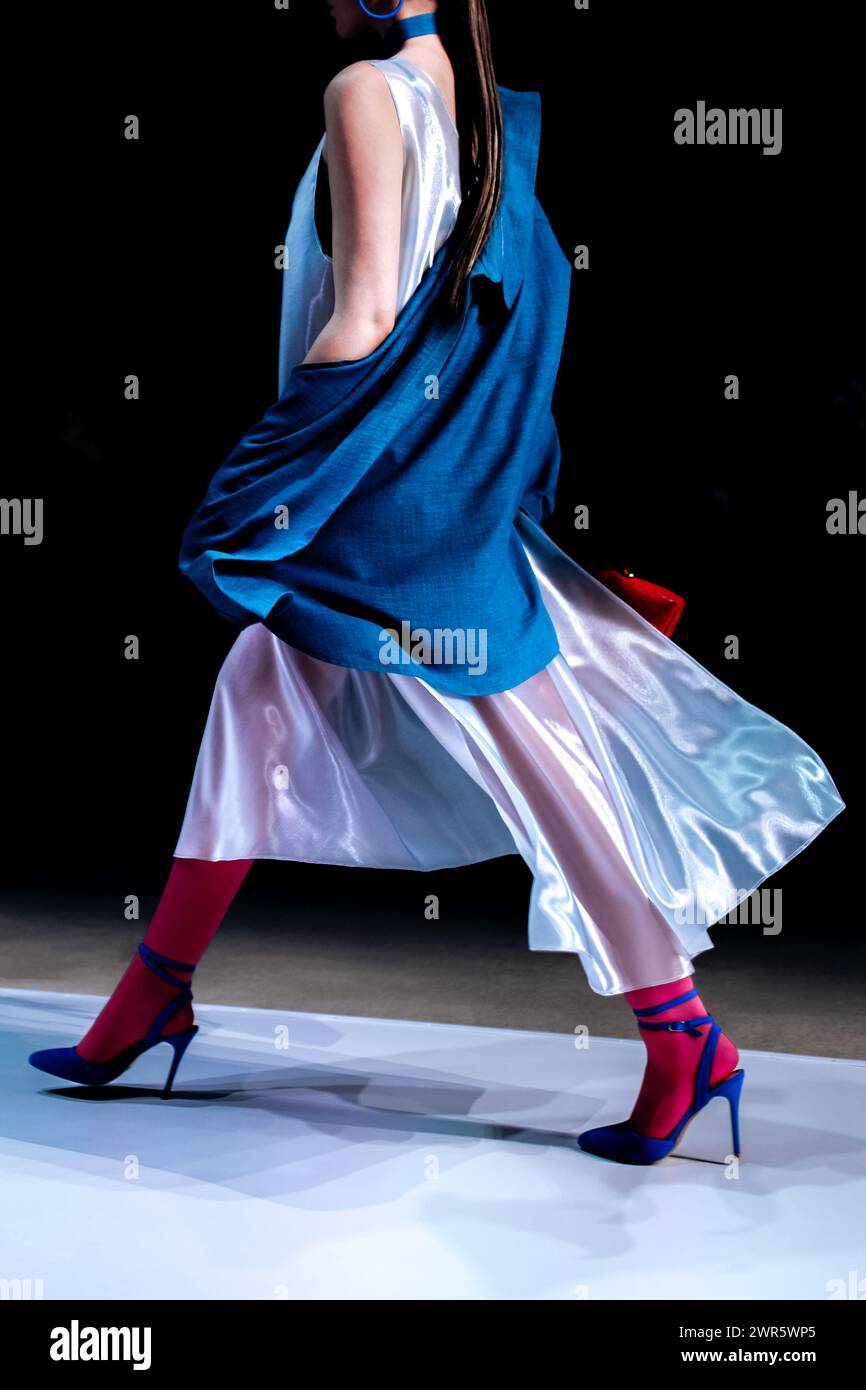 Modisches, stylisches Kleid im Damenlook, blaues Sakko und High Heels, Modemodell, das auf dem Podium steht Stockfoto