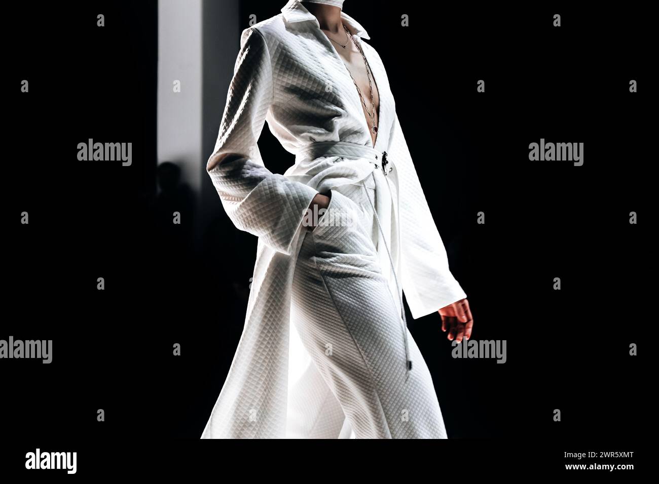 Modische Details eines langen weißen Mantels. Freizeitmode für Damen. Seitenansicht Stockfoto