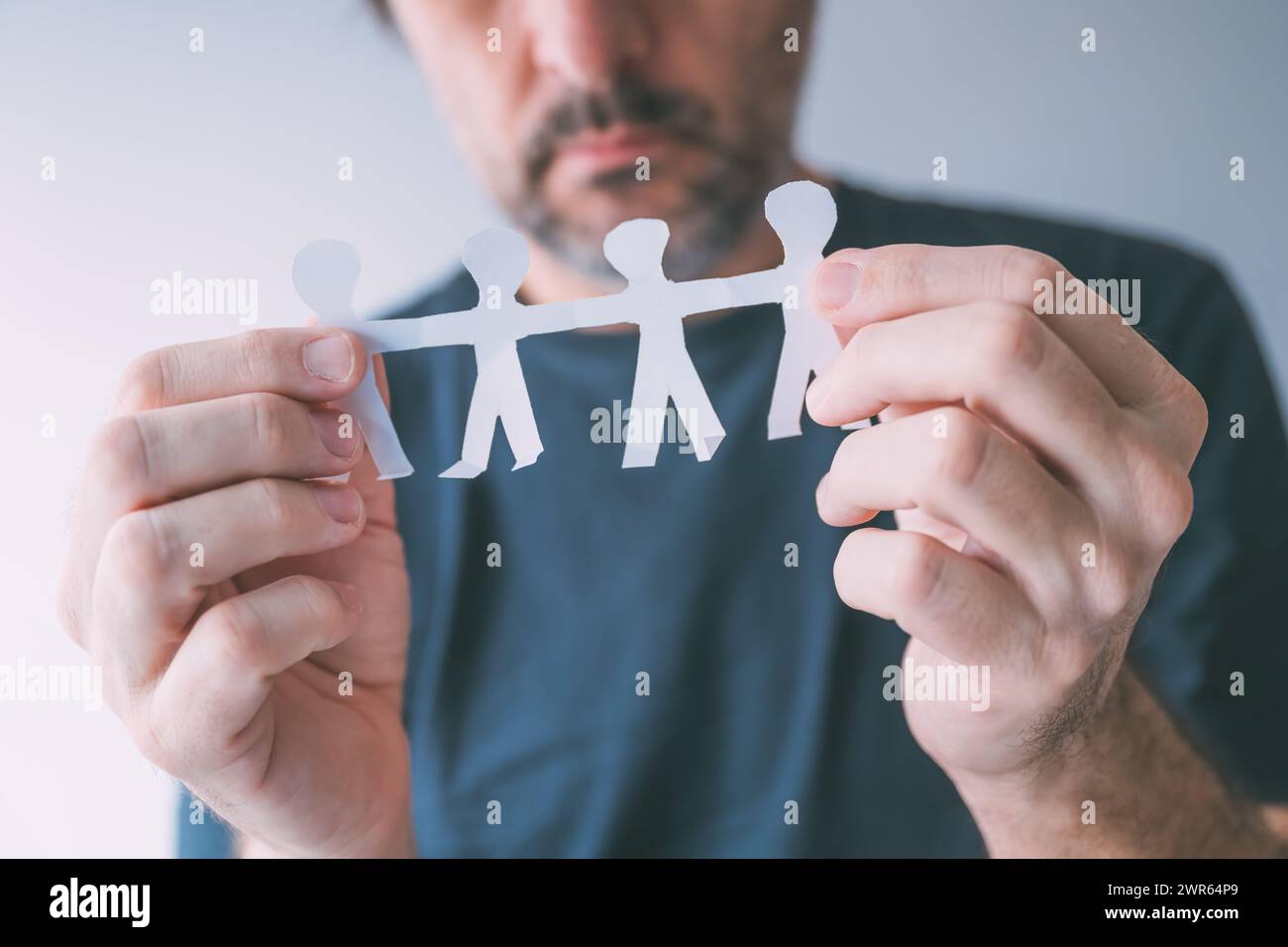 Mann mit ausgeschnittenen Papiermenschen Familie von vier Personen, selektiver Fokus Stockfoto