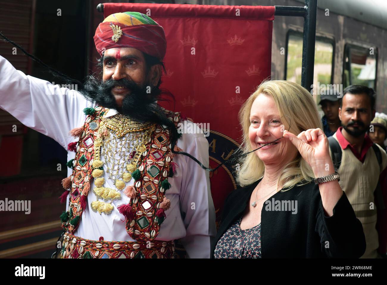 6. März 2024, Bikaner, Rajasthan, Indien: Rajashtani-Künstler mit langem Schnurrbart posiert für Fotos mit einem Touristen nach der Ankunft des Maharajas Express-Zuges in Bikaner. (Kreditbild: © Dinesh Gupta/Pacific Press via ZUMA Press Wire) NUR REDAKTIONELLE VERWENDUNG! Nicht für kommerzielle ZWECKE! Stockfoto