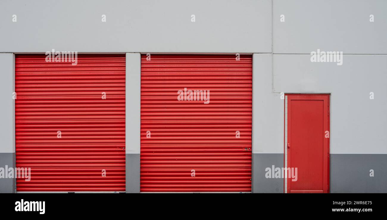 Die symmetrischen roten Garagentore einer Lagereinrichtung. Stockfoto