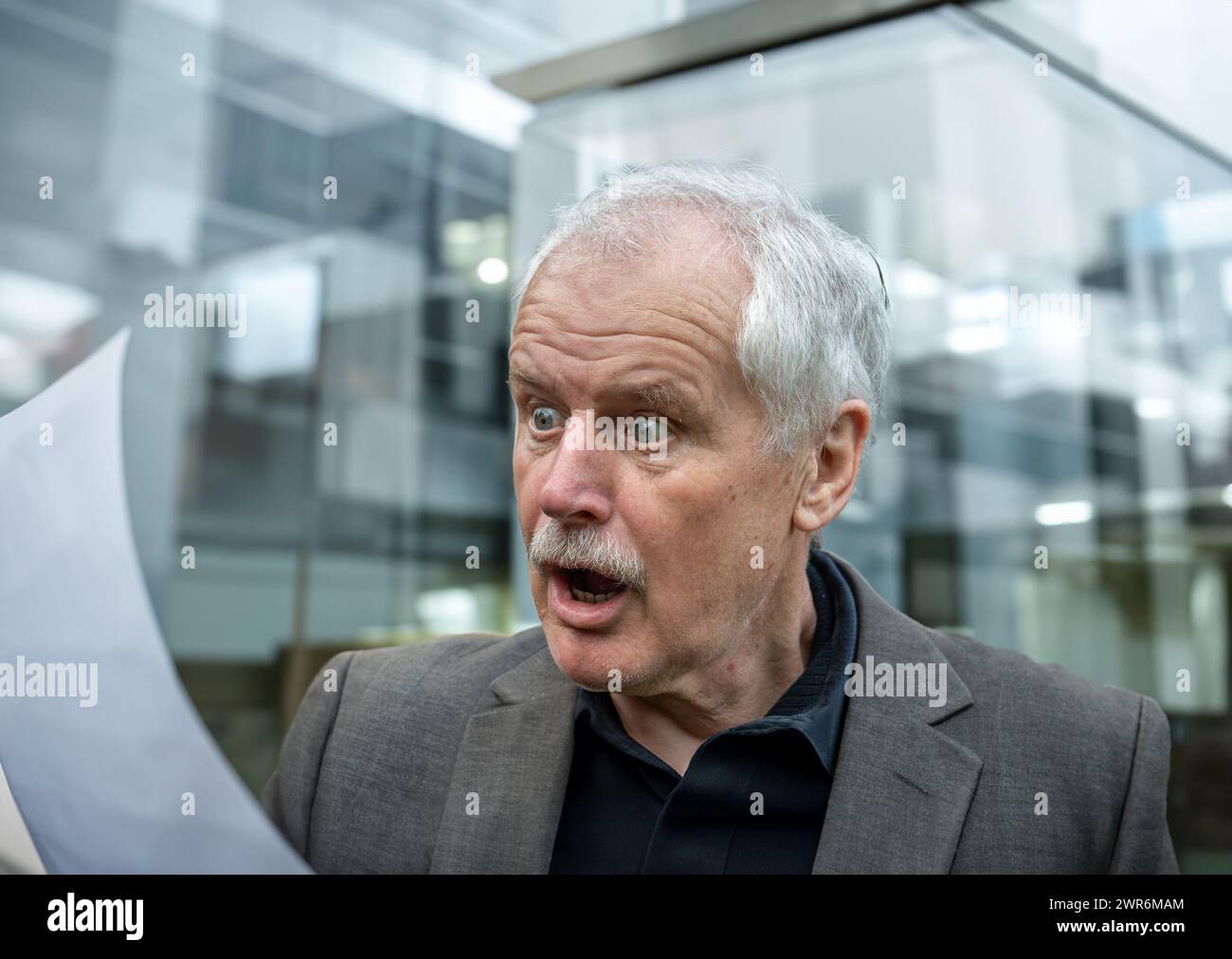 Senior Mann, der schockiert auf ein Dokument schaut. Stockfoto