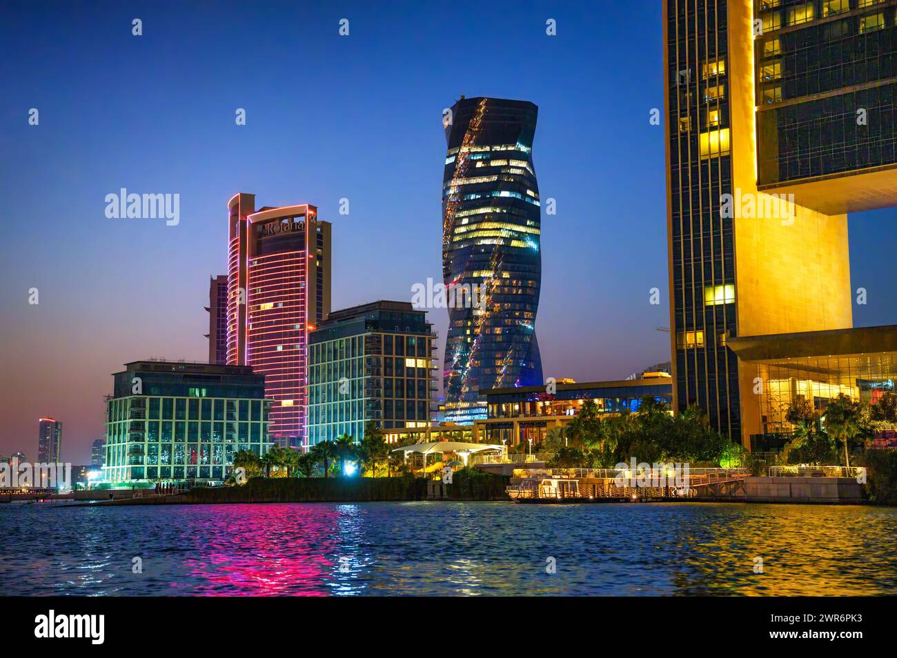 Nachtblick auf moderne Resorts, die sich im Wasser in Bahrain spiegeln Stockfoto