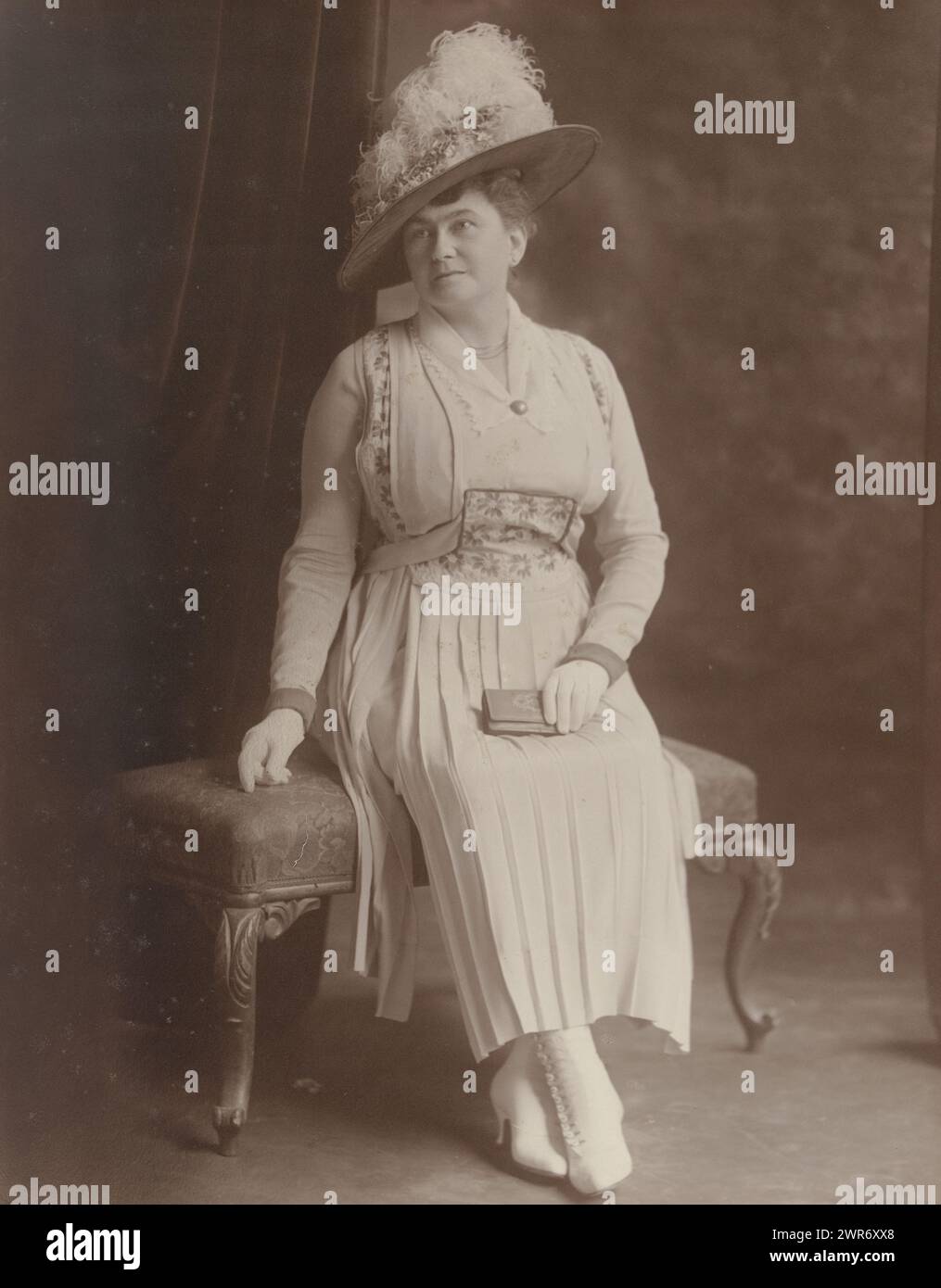 Studio-Porträt sitzende Frau mit Hut und Brieftasche, Bushnelf, Vereinigte Staaten von Amerika, 1910 - 1930, fotografischer Träger, Gelatinefarbendruck, Höhe 352 mm x Breite 277 mm, Fotografie Stockfoto