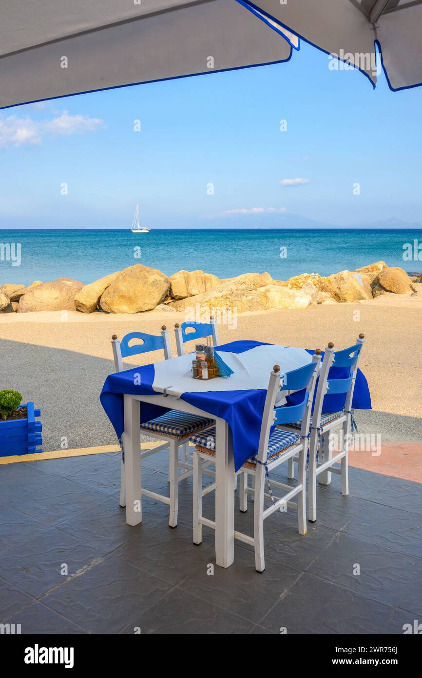 Tisch mit Stühlen im griechischen Restaurant am Meer. Kardamena Dorf auf der Insel Kos, Griechenland Stockfoto