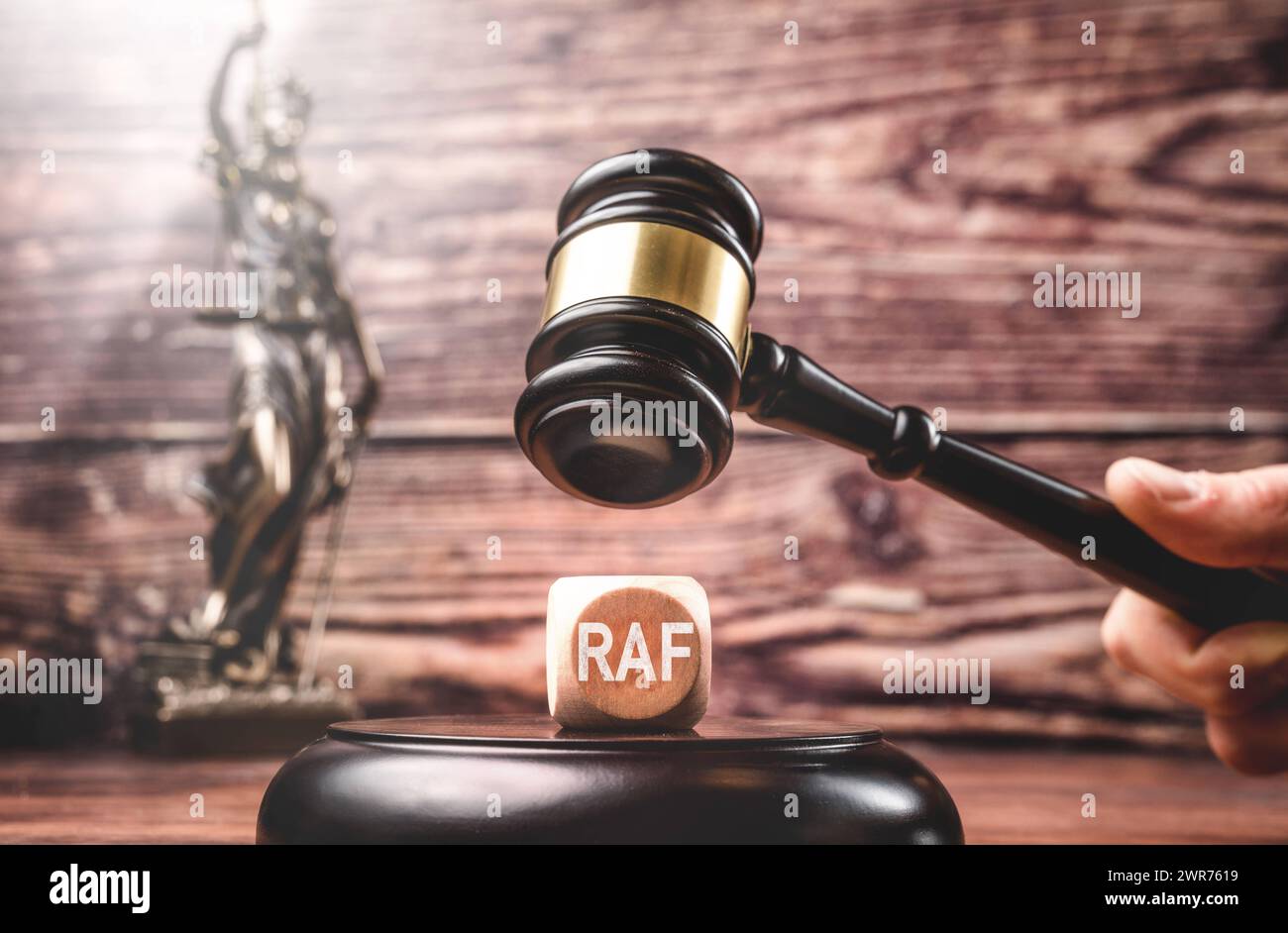 Deutschland - 11. März 2024: Hand mit Richterhammer über einem Würfel mit Aufschrift: RAF Rote Armee Fraktion FOTOMONTAGE *** Hand mit Richterhammer über einem Würfel mit Aufschrift: RAF Rote Armee Fraktion FOTOMONTAGE Stockfoto