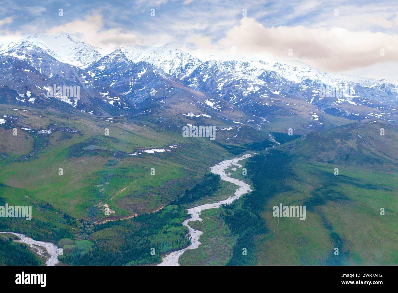 Aus der Vogelperspektive auf die Berge Alaskas und den Fluss, der durch das abgelegene Tal fließt. Stockfoto