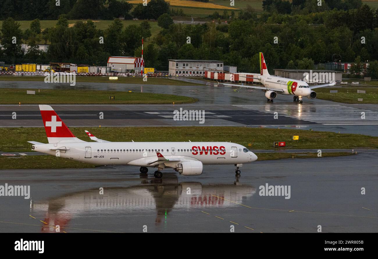 Ein Airbus A220-300 von Swiss International Airlines wartet bis er auf die Startbahn kann. Registrierung HB-JCS. Dahinter rollt ein Airbus A319-111 von Stockfoto