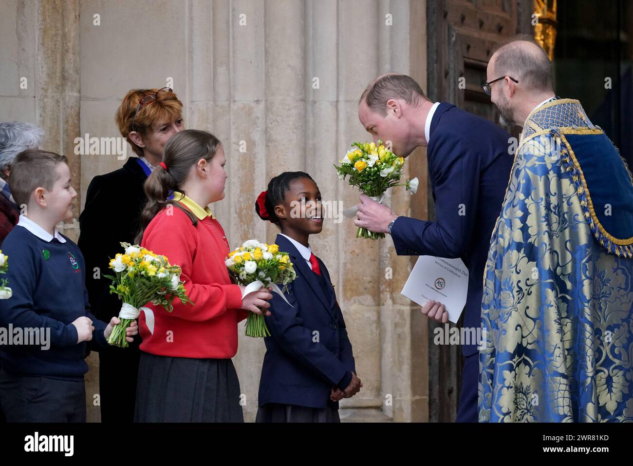 Der Prinz von Wales riecht einen Blumenstrauß, den er bekommt, als er den jährlichen Commonwealth Day Service in der Westminster Abbey in London verlässt. Bilddatum: Montag, 11. März 2024. Stockfoto