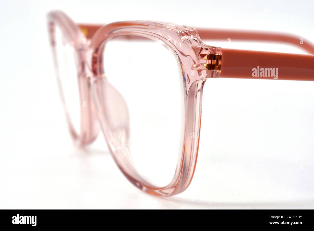 Nahaufnahme einer rosa gerahmten Brille auf weißem Hintergrund. Stockfoto