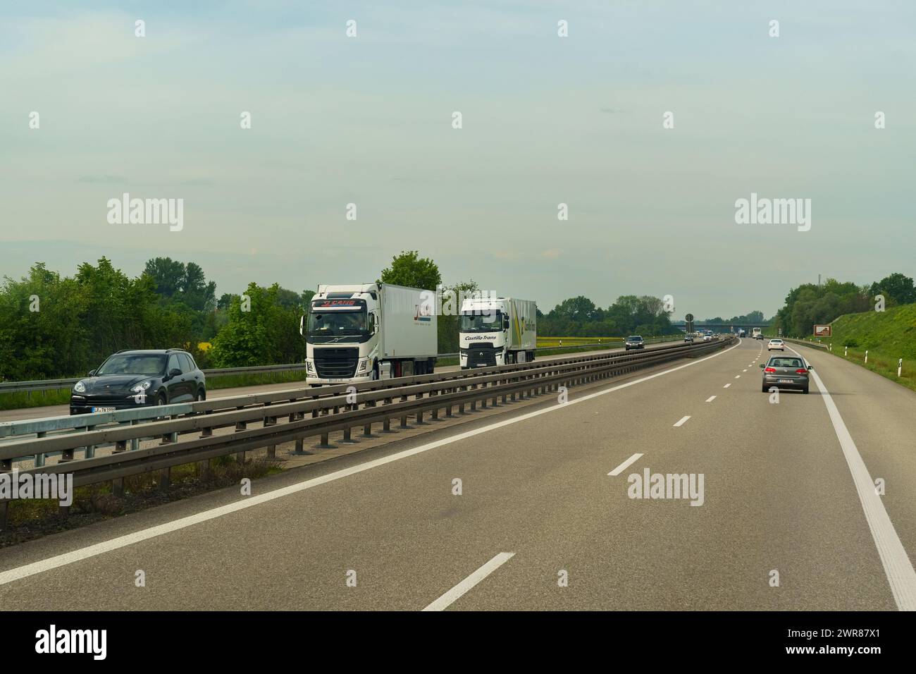 Lyon, Frankreich - 7. Mai 2023: Ein Lkw-Paar fährt auf einer Autobahn, umgeben von anderen Fahrzeugen. Die Straße erstreckt sich bis in die Ferne unter klarem Himmel Stockfoto