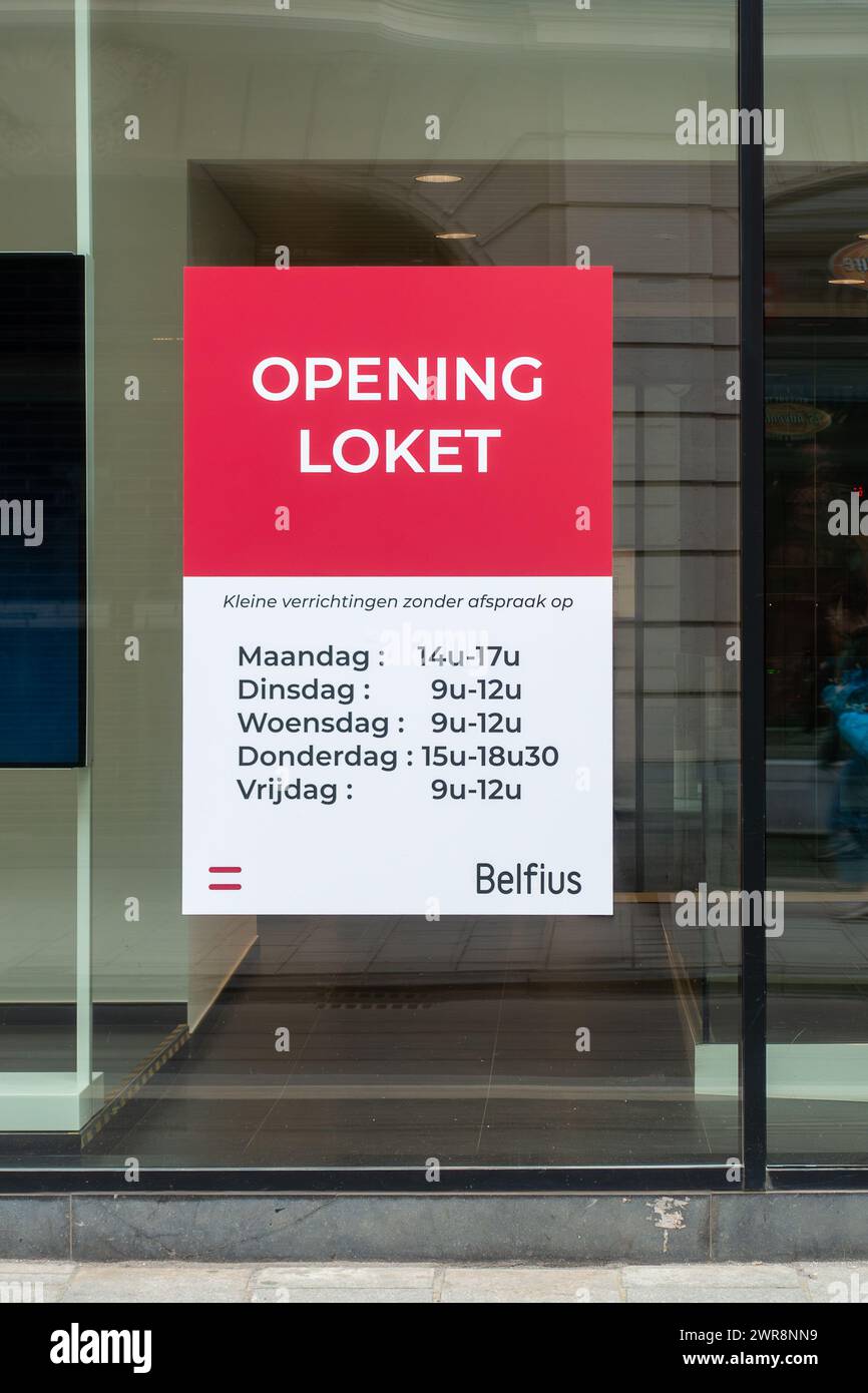 Bürofenster mit den Öffnungszeiten der Bankfiliale von Belfius in Gent, Ostflandern, Belgien Stockfoto