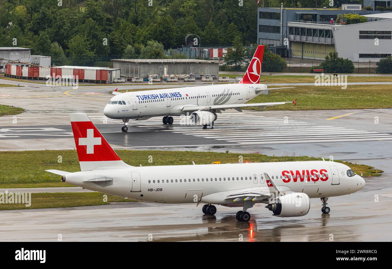 Ein Airbus A321-200 von Turkish Airlines startete von Piste 28 auf dem Flughafen Zürich. Registrierung TC-JSC. Davor wartet ein Airbus A220-100 von Swis Stockfoto