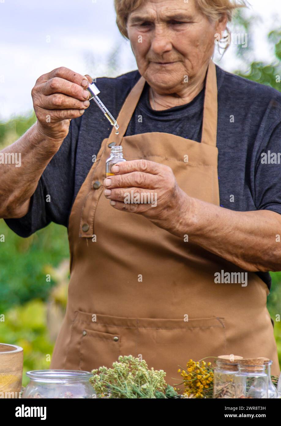 Eine ältere Frau hält einen Kräuterextrakt in den Händen. Selektiver Fokus. Natur. Stockfoto