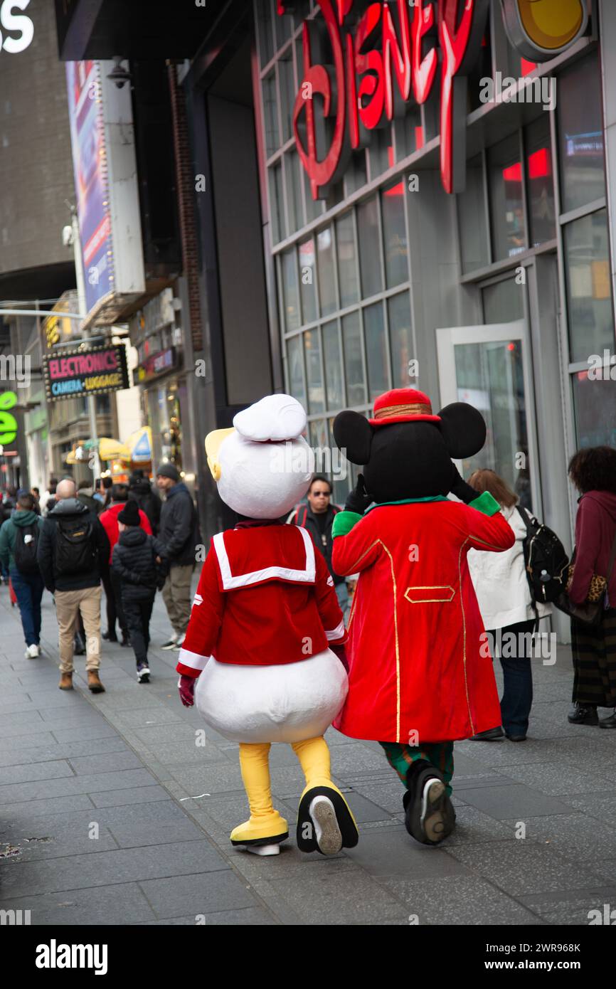 Mickey Mouse und Donald Duck schlendern am Disney Store entlang des Broadway am Times Square, New York City. Stockfoto