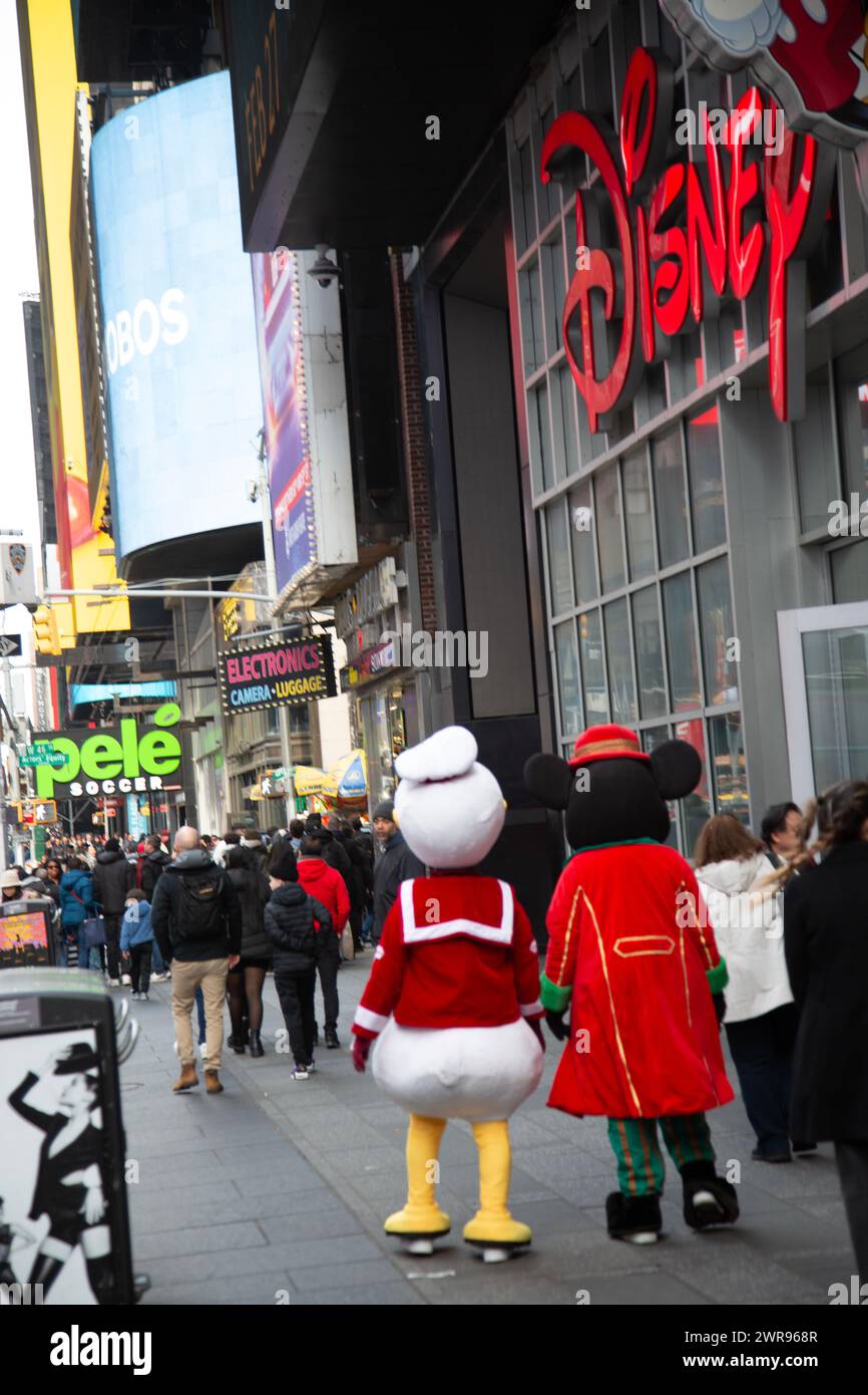 Mickey Mouse und Donald Duck schlendern am Disney Store entlang des Broadway am Times Square, New York City. Stockfoto