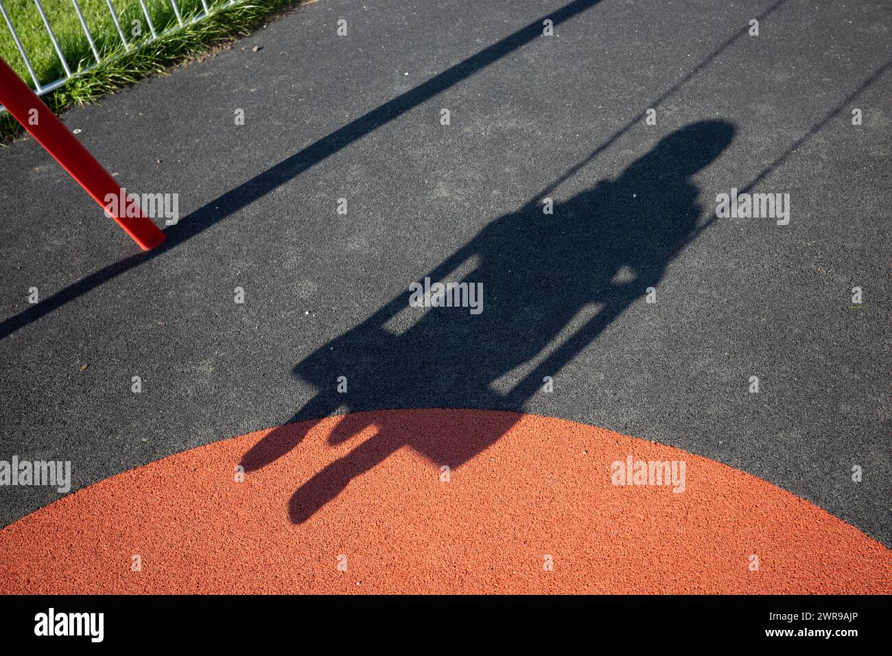 Kinderschatten auf einer Schaukel in einem Spielpark, Großbritannien Stockfoto