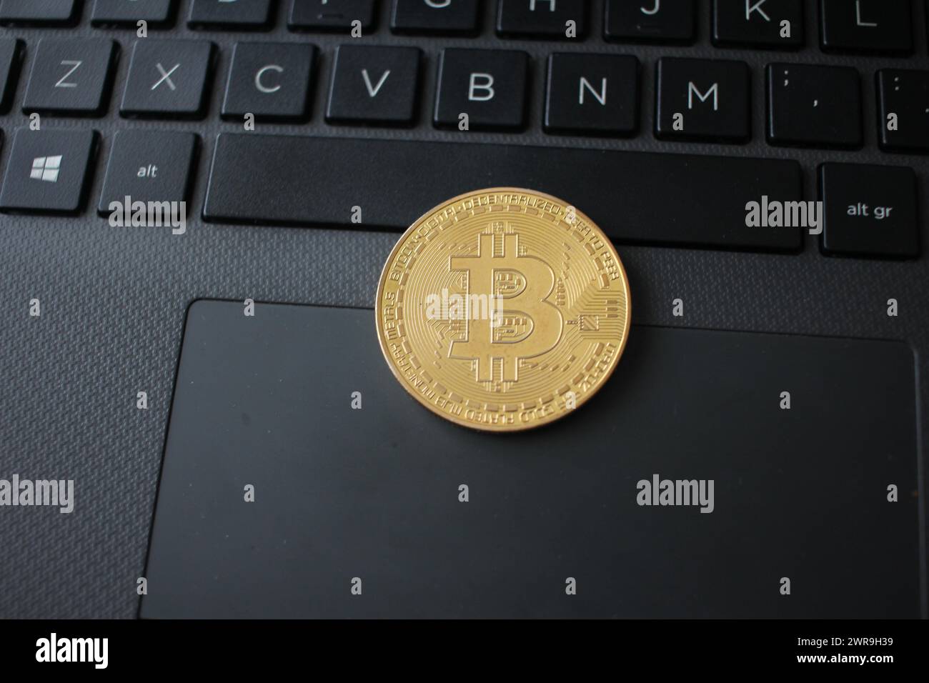 Ein Bitcoin auf einer schwarzen Tastatur. Konzept: Ist Bitcoin das digitale Geld der Zukunft? Stockfoto