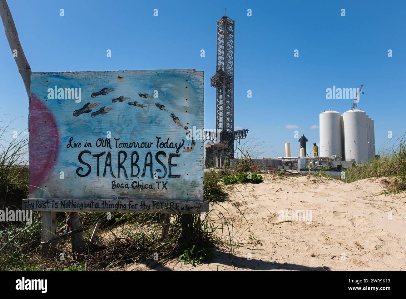 SpaceX und Sternenbasis Schild am Boca Chica Beach, Texas mit Ausrüstung im Hintergrund. Stockfoto