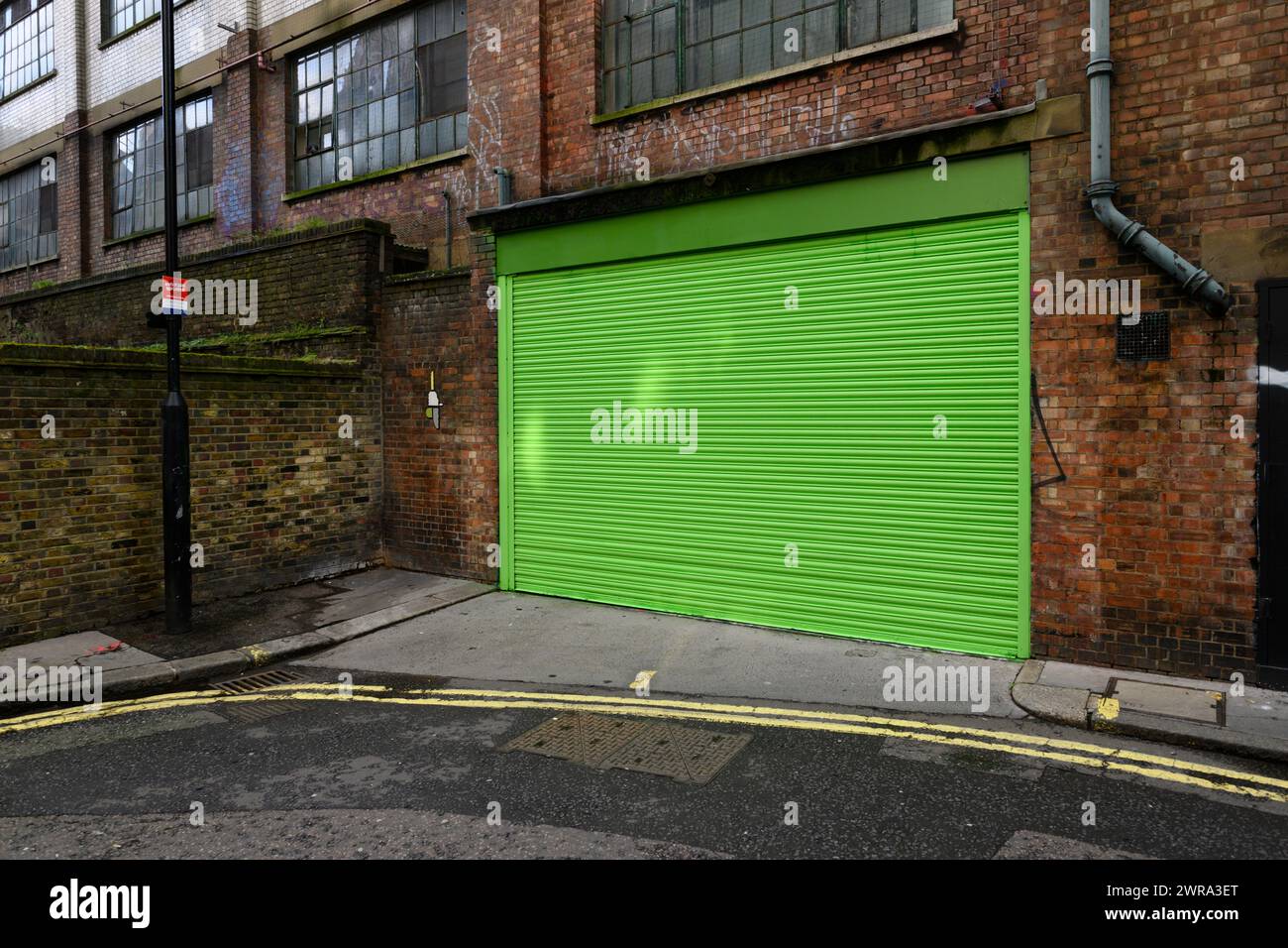 Ein neu lackiertes grünes Garagentor, Ingestre Place, Soho, London, Großbritannien. Februar 2024 Stockfoto