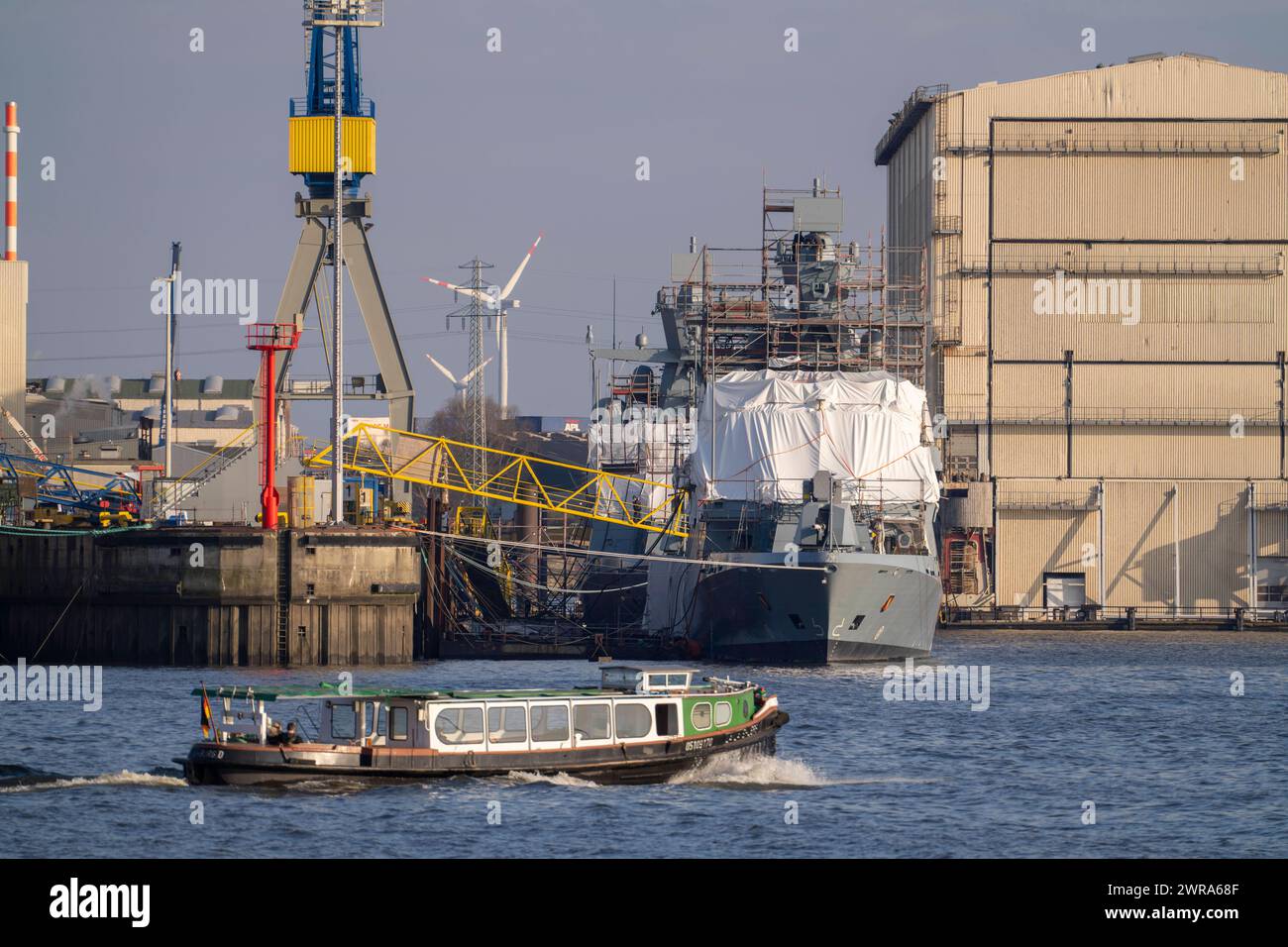 Blohm Voss Schiffswerft, neue Korvette der Bundesmarine, Karlsruhe, bei der Fertigstellung, eingerüstetes Schiff, Hafenrundfahrt Barkasse auf der Elbe, Hamburg, Deutschland Hamburg Hafen *** Werft Blohm Voss, neue Korvette der Deutschen Marine, Karlsruhe, bei Fertigstellung, Gerüstschiff, Hafenrundfahrt Start auf der Elbe, Hamburg, Deutschland Hamburg Hafen Stockfoto