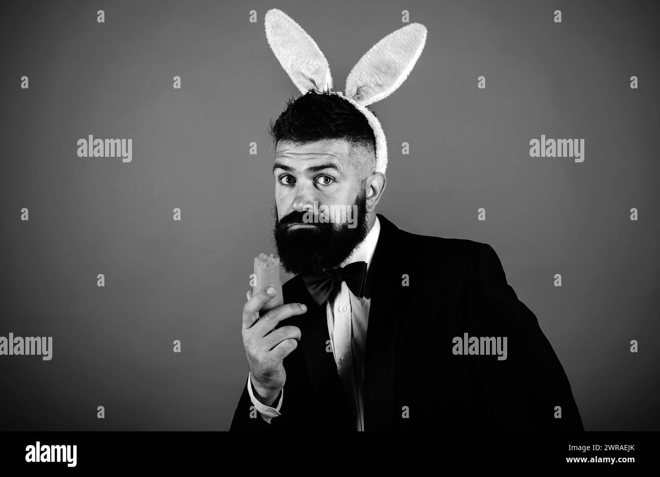 Lustige Häschen Mann am ostertag. Frohe ostern und Feiertage. Knabbert eine Karotte wie ein Hase. Frühlingsferien und Ostertag. Lustige Vorbereitung auf Ostern. Kopieren Stockfoto