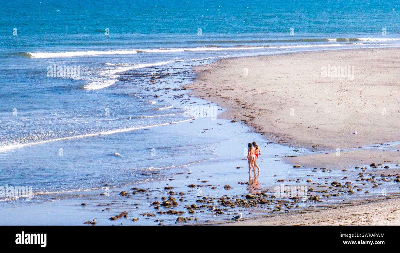 Zwei Frauen laufen am Malibu Beach in Malibu, Kalifornien. Malibu ist ein beliebtes Touristenziel an der kalifornischen Küste, das für seine Strände bekannt ist. Stockfoto