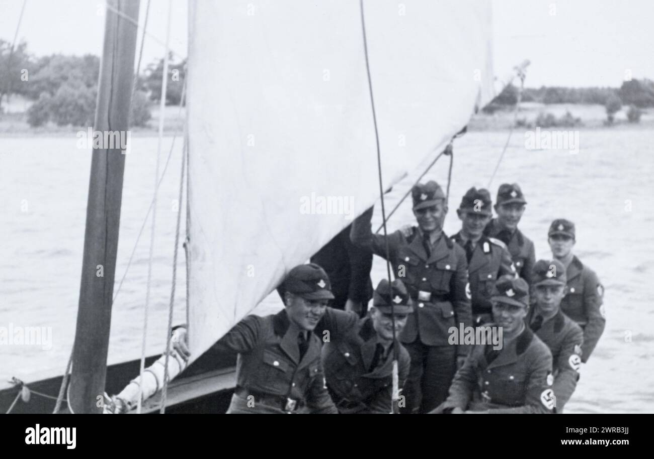 Ein Truppenführer und arbeitende Männer des Reichsarbeitsdienstes auf einem Segelboot während des Deutschen Dritten Reichs. Stockfoto